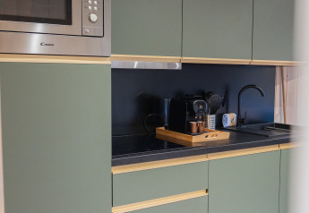 Cocina moderna en Ecolodge - Care accessible en Hameau de l'Ourthe, Bélgica, con gabinetes verdes y microondas.