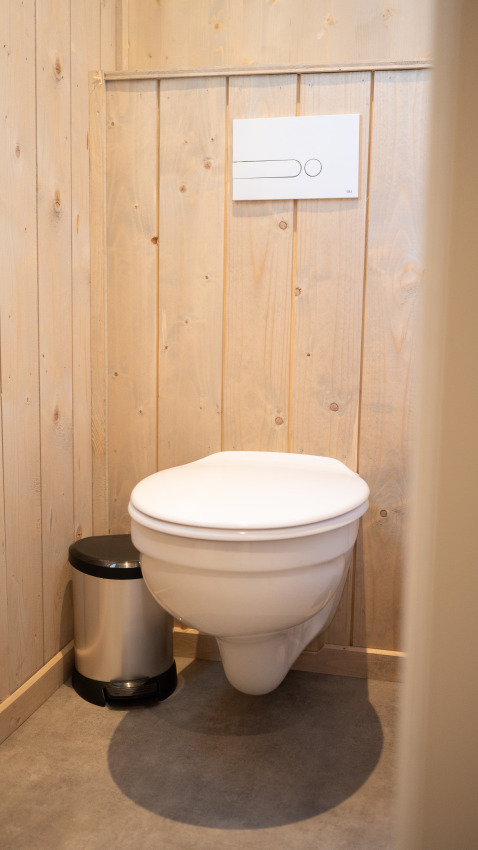 Badkamer met zwevend toilet en vuilnisbak in Ecolodge - Care accessible in Hameau de l'Ourthe, België.