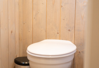 Baño con inodoro suspendido y papelera en Ecolodge - Care accessible en Hameau de l'Ourthe, Bélgica.