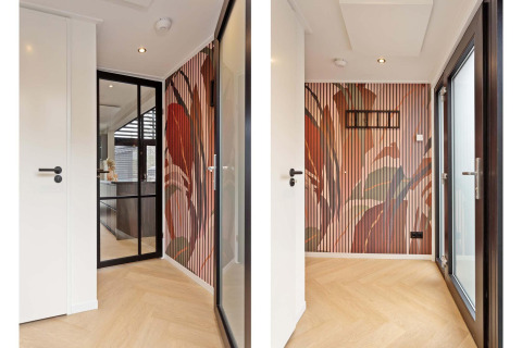 Entrada luminosa de lodge con puerta de vidrio, pared con paneles estampados y suelo de madera clara.