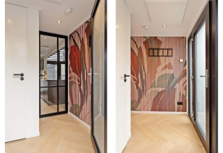 Entrada luminosa de lodge con puerta de vidrio, pared con paneles estampados y suelo de madera clara.