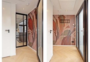Entrada luminosa de lodge con puerta de vidrio, pared con paneles estampados y suelo de madera clara.
