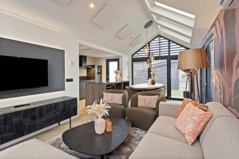 Sala de estar de lodge moderna con grandes ventanales, decoración elegante y asientos confortables.