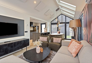 Sala de estar de lodge moderna con grandes ventanales, decoración elegante y asientos confortables.