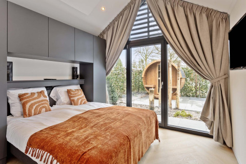 Chambre moderne au Lodge Royal Eco 6 personen de Résidence Lage Vuursche, avec vue sur sauna et grandes fenêtres.