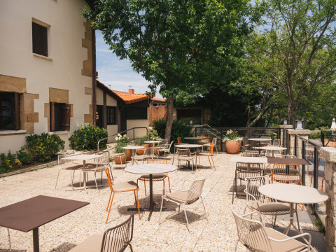 Udendørs terrasse på Wecamp San Sebastián feriepark i Baskerlandet, Spanien med borde og stole.