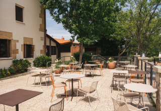 Terrasse extérieure du parc de vacances Wecamp San Sebastián au Pays basque, Espagne, avec tables et chaises.