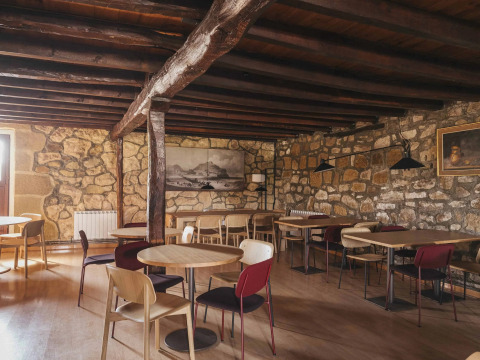 Café rústico con paredes de piedra y vigas de madera en Wecamp San Sebastián, parque vacacional en País Vasco.