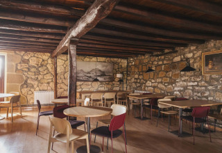 Caffè rustico con pareti in pietra e travi in legno a Wecamp San Sebastián, villaggio turistico nei Paesi Baschi.