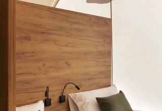 Interior de una tienda safari Glamping Family Plus con dos camas en Wecamp San Sebastián, España, decoración moderna.