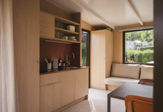 Interiør af Mobile home «Couple Plus» på Wecamp San Sebastián, moderne køkken og hyggelig stue.