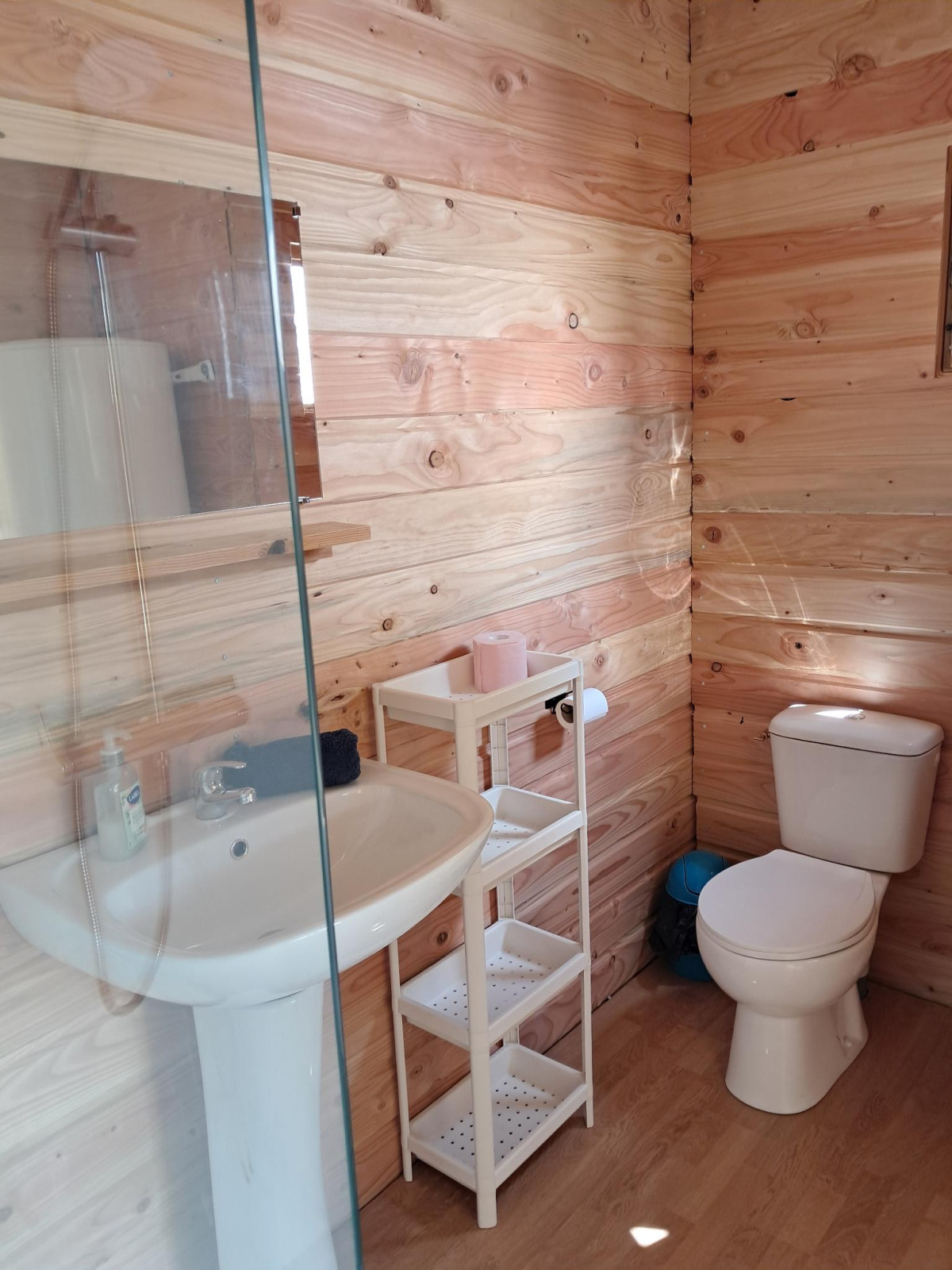 Badkamer met houten wanden, wastafel, wc en rek in de Sybley Apex tent op Campsite Junora, Frankrijk.