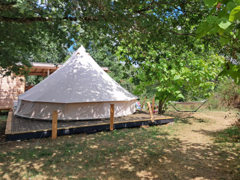 Tenda Sybley Apex al campeggio Junora in Francia, circondata da alberi e natura, amaca sullo sfondo.