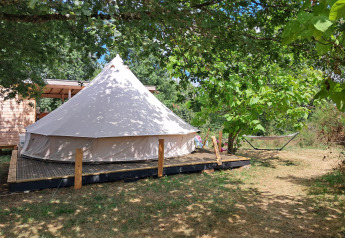 Tenda Sybley Apex al campeggio Junora in Francia, circondata da alberi e natura, amaca sullo sfondo.