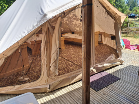Buitenzicht op de Sibley Apex tent bij Campsite Junora in Frankrijk, met gezellig interieur en houten terras.