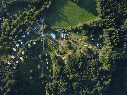 Aerial view of Junora campsite holiday park in Nouvelle-Aquitaine, France, surrounded by lush trees.