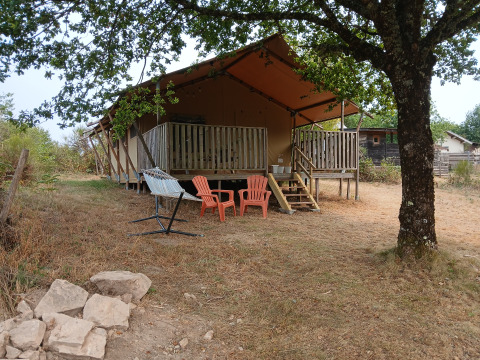 Tente safari 'Luxury and spacious Eco-lodge' au camping Junora en France, entourée d'arbres et de nature.