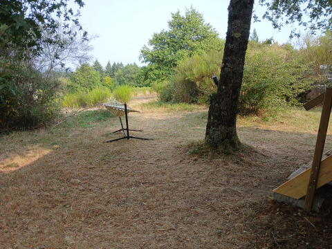 Vue en plein air avec support de hamac à l'éco-lodge luxueuse et spacieuse du Camping Junora, France.