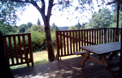 Wooden deck with picnic bench at the safari tent 'Luxury and spacious Eco-lodge', Campsite Junora, France.