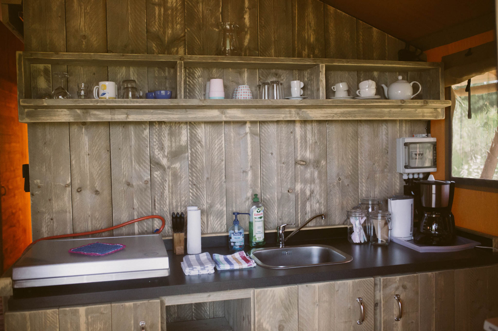 Volledig uitgeruste houten keuken in een luxe safaritent eco-lodge op Camping Junora in Frankrijk.