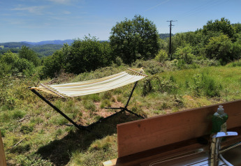 Vue depuis la tente Bell XL au camping Junora en France, avec un hamac et un évier au premier plan.