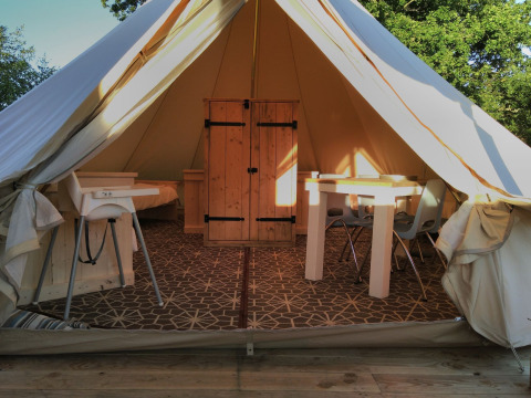 Indgang til en Bell XL familietelt-lodge på Campsite Junora i Frankrig med moderne møbler.