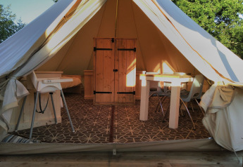 Entrée du lodge Bell XL family tent au camping Junora en France, mobilier moderne visible à l’intérieur.
