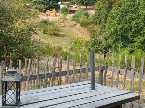 Vista dalla tenda familiare Bell XL al campeggio Junora, Francia, con tavolo in legno e area giochi.