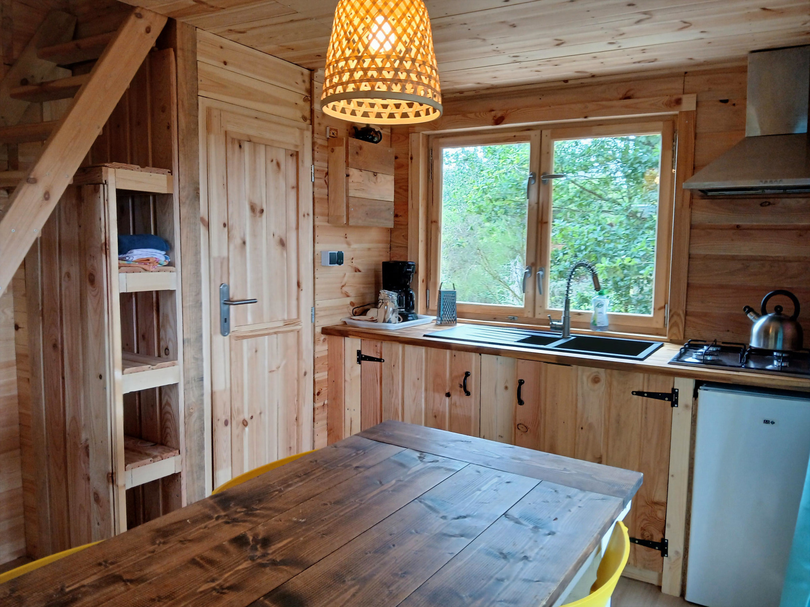 Houten interieur van de Avignon-lodge op Camping Junora in Frankrijk, met keuken en eethoek.