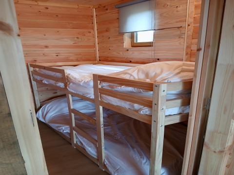 Gezellige houten kamer met stapelbed in lodge ‘Avignon’, Camping Junora, met witte dekbedden, Frankrijk.
