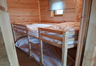 Gezellige houten kamer met stapelbed in lodge ‘Avignon’, Camping Junora, met witte dekbedden, Frankrijk.
