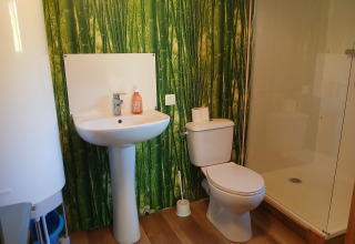 Moderne badkamer met bamboebehang, lavabo, toilet en douche in de Emperor Bell Tent, Campsite Junora.