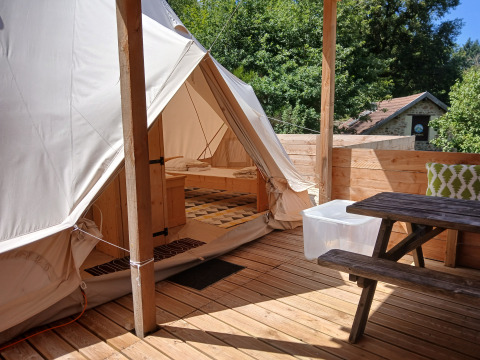 Emperor Bell Tent spaziosa con terrazza in legno e tavolo da picnic al Campeggio Junora, Francia.