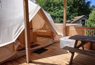 Ruime Emperor Bell Tent met houten terras en picknickbank bij Campsite Junora, Frankrijk.