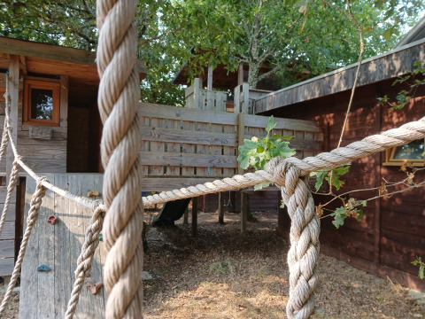 Boomhut bij Eco-Chalet EXTRA op Camping Junora in Frankrijk, met touwen en houten speelstructuur.