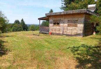 Chalet ecologico in legno con pannello solare, immerso nel verde al campeggio Junora, Francia.