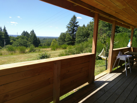 Blick von der Holzveranda des 'Self-sufficient, luxury eco-chalet' auf dem Campsite Junora in Frankreich.