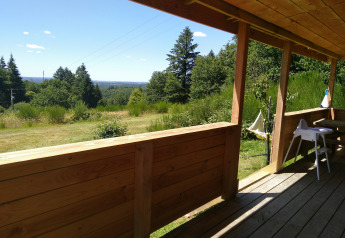 Blick von der Holzveranda des 'Self-sufficient, luxury eco-chalet' auf dem Campsite Junora in Frankreich.