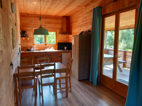 Interno di uno chalet ecologico di lusso autosufficiente al Campeggio Junora con cucina e vista terrazza.