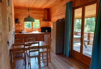 Interno di uno chalet ecologico di lusso autosufficiente al Campeggio Junora con cucina e vista terrazza.