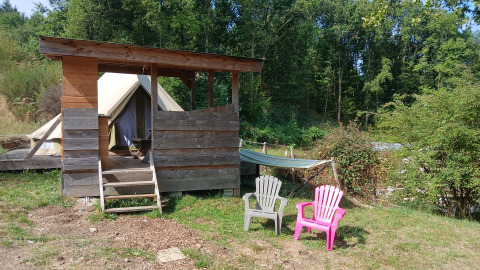 Outdoor view at Bell tent «6M» at Campsite Junora in France, showing tent, shelter, lawn chairs and hammock.