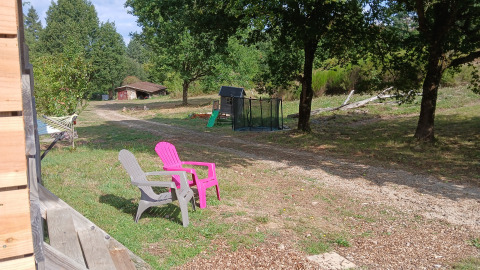 Scenic outdoor area at Bell tent «6M» in Campsite Junora, France, with chairs, trees, and a play area.