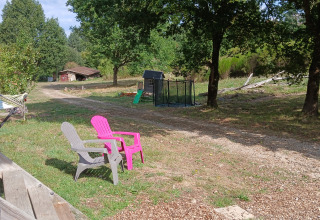 Scenic outdoor area at Bell tent «6M» in Campsite Junora, France, with chairs, trees, and a play area.