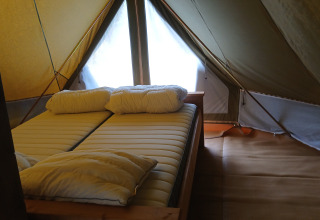 Interior view of Bell tent «6M» at Campsite Junora in France, showing a comfortable double bed setup.