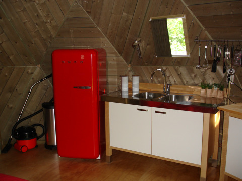 Kleine Küche in einer Holz-Iglu mit rotem Retro-Kühlschrank und Doppelspüle im Holiday Park Delftse Hout.