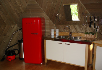 Petite cuisine d’igloo en bois avec réfrigérateur rouge rétro et évier au Holiday Park Delftse Hout.