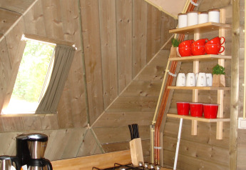 Tiny kitchen inside the Wooden Igloo at Holiday Park Delftse Hout in the Netherlands, with wood interior.
