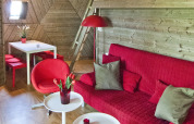 Stue i tiny house Wooden Igloo, Holiday Park Delftse Hout, med rød sofa, spisebord og unik lampe.