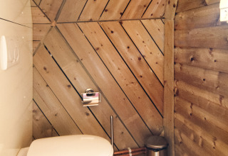 Badeværelse med trægulv og trævægge i en tiny house ved Holiday Park Delftse Hout i Nederlandene.