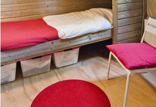 Gemütlicher Schlafbereich im Wooden Igloo, Holiday Park Delftse Hout, mit Holzverkleidung und roten Akzenten.